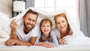 Happy Family Playing Smiling In Bed